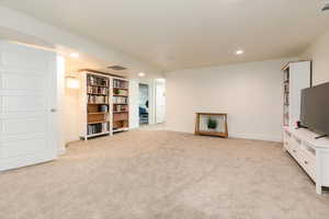 Unfurnished living room with light carpet and recessed lighting