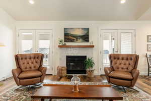 Living room featuring french doors, wood finished floors, a tile fireplace, and recessed lighting