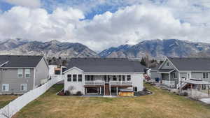 Back of house with a patio, a deck with mountain view, and a fenced backyard