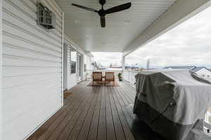 Wooden terrace with a grill and ceiling fan