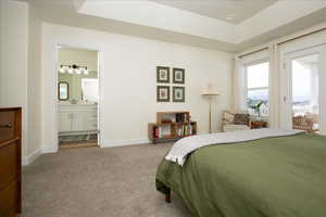 Bedroom with light carpet and ensuite bath