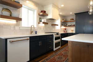 Kitchen with open shelves, white appliances, light stone counters, dark wood finished floors, and recessed lighting
