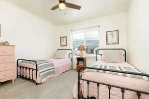 Bedroom with light colored carpet and a ceiling fan