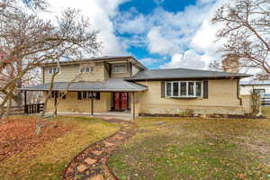 View of the front facade with brick siding and a covered porch.