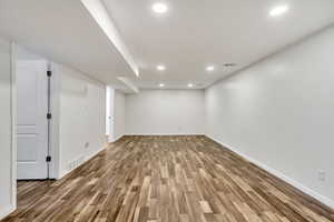 Finished basement with wood finished floors and recessed lighting