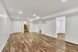 Finished below grade area with light wood-type flooring and recessed lighting