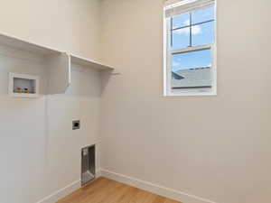 Laundry area featuring light wood-style flooring, hookup for a washing machine, and hookup for an electric dryer