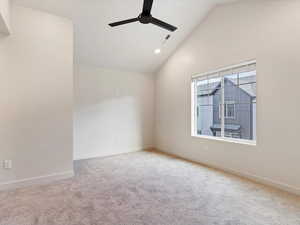 Empty room featuring vaulted ceiling, light colored carpet, a ceiling fan, and recessed lighting