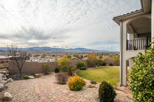 Fenced backyard with a mountain view and a balcony