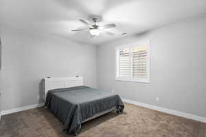 Carpeted bedroom featuring baseboards and a ceiling fan