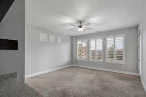 Spare room featuring ceiling fan and light colored carpet