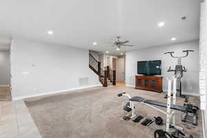 Exercise area with light colored carpet, ceiling fan, light tile patterned floors, and recessed lighting