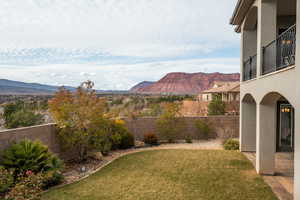 Fenced backyard featuring a mountain view and a balcony