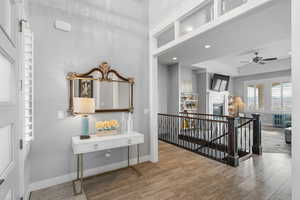 Hall with an upstairs landing, light wood-type flooring, and recessed lighting