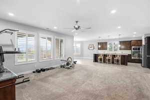 Exercise area with ceiling fan, recessed lighting, and light colored carpet