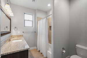 Bathroom featuring vanity and shower / bath combination with curtain