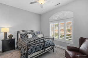 Bedroom with light carpet and a ceiling fan