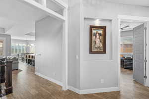 Hall featuring wood finished floors, a chandelier, and crown molding