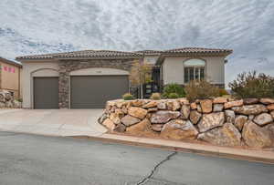 Mediterranean / spanish house featuring stucco siding, driveway, a garage, and a tile roof