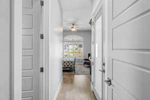 Hallway with baseboards and light wood-style floors