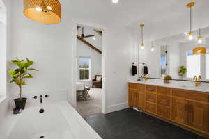 primary Ensuite bathroom featuring a garden tub, double vanity, recessed lighting, a ceiling fan, and dark tile patterned floors