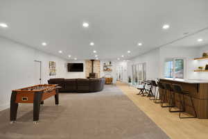 down stairs main living area walkout basement with recessed lighting, a wood stove, and light wood-style floors