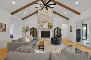 Living room with light wood-style floors, a fireplace, ceiling fan, and recessed lighting