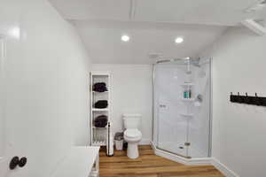 upstairs Full bath with a shower stall, light wood-style flooring, recessed lighting