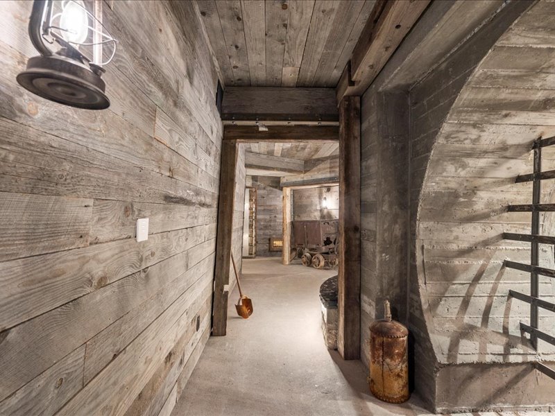 Hall featuring wooden walls, unfinished concrete floors, and wooden ceiling