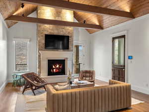 Living room featuring hardwood / wood-style floors, a fireplace, a high wooden beamed ceiling, and healthy amount of natural light