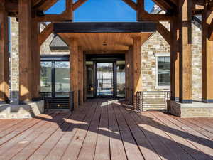 Property entrance with stone siding and a deck