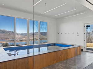 Bathroom featuring a bathtub, a water and mountain view, and dark marble finish flooring