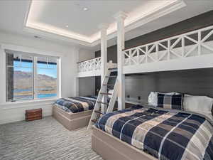 Bedroom featuring a tray ceiling, a mountain view, carpet, and recessed lighting