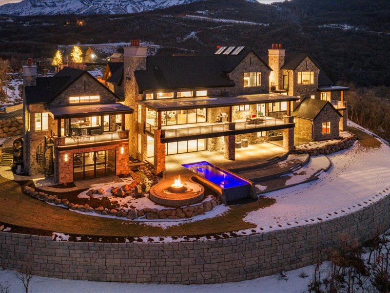 Rear view of house with a chimney, a mountain view, a balcony, and a patio