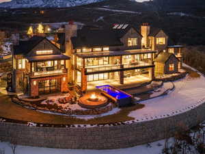 Rear view of house with a chimney, a mountain view, a balcony, and a patio
