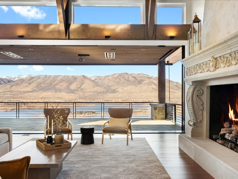 Sitting room with a premium fireplace, a mountain view, wood finished floors, and expansive windows