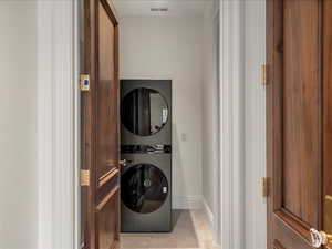 Laundry area featuring baseboards and stacked washer and dryer