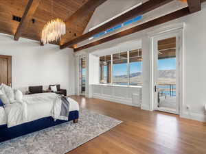 Bedroom featuring access to outside, light wood-type flooring, a mountain view, lofted ceiling with beams, and wooden ceiling