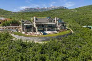 Stone and glass contemporary residence featuring multiple balconies and terraces