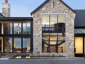 Doorway to property with stone siding and a chimney