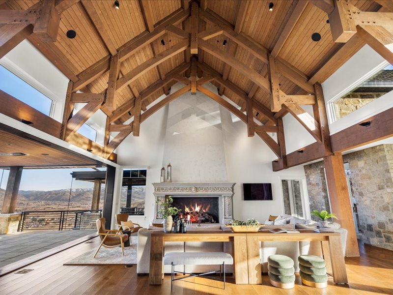 Living room with a fireplace, a mountain view, hardwood / wood-style floors, a high wood beamed ceiling, and plenty of natural light