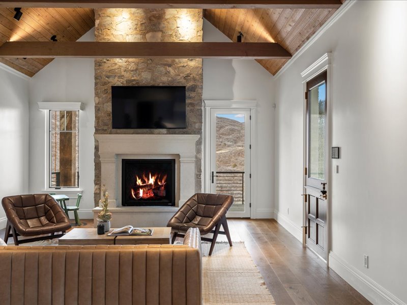 Living room featuring a fireplace, a high wooden beamed ceiling, and wood-type flooring