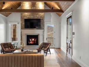 Living room featuring a fireplace, a high wooden beamed ceiling, and wood-type flooring