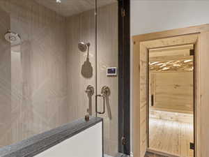 Full bathroom featuring a shower stall, a sauna / steam room, and wood finished floors