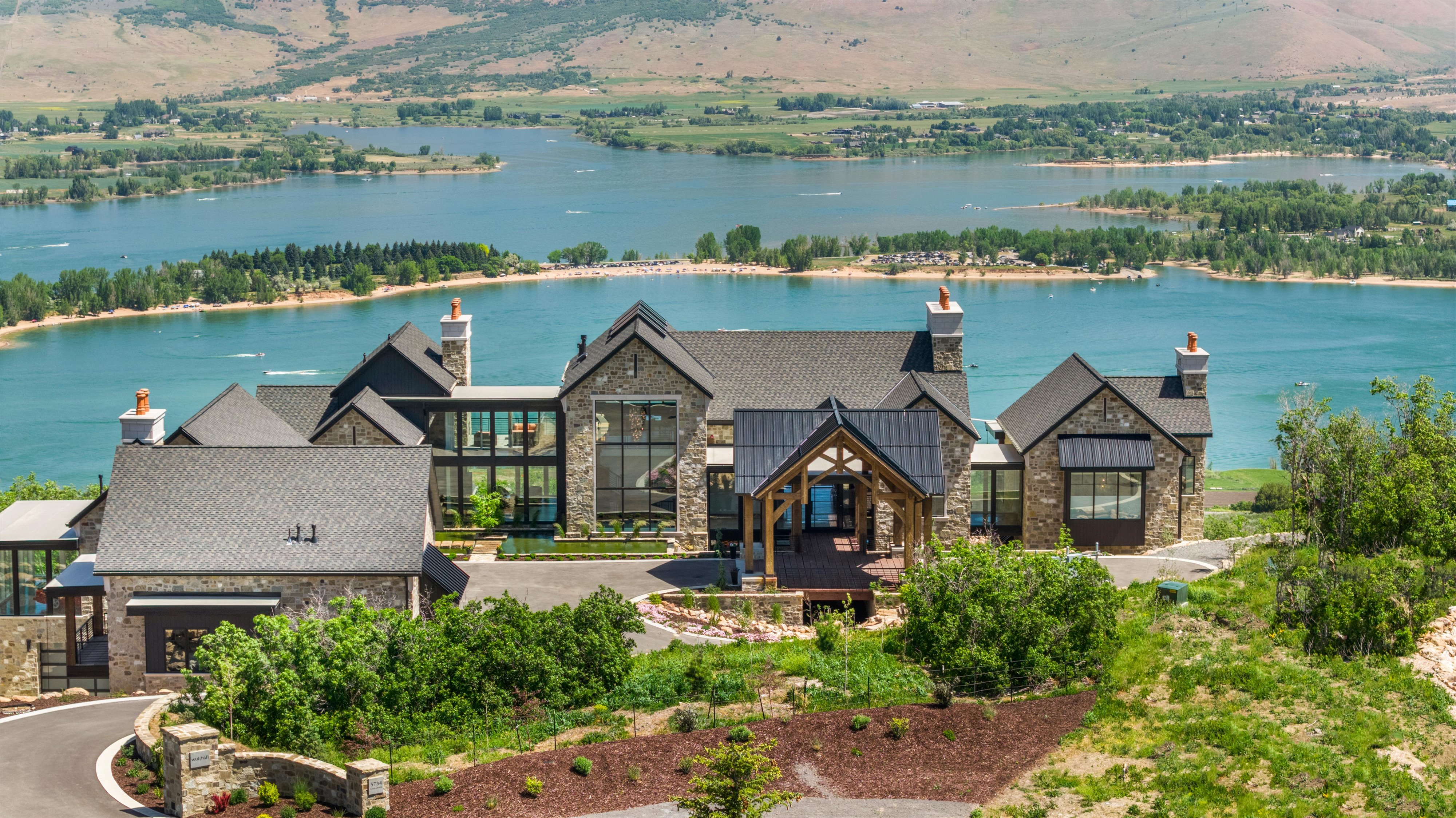 Expansive stone and shingle-roof residence featuring multiple gables and prominent chimneys