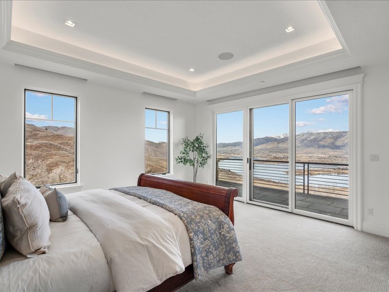 Carpeted bedroom with access to outside, a raised ceiling, and a mountain view