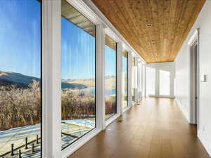 Hall with wood ceiling, wood-type flooring, and a mountain view