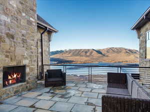 View of patio with an outdoor stone fireplace and a mountain view