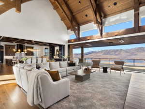 Living room with a mountain view, hardwood / wood-style floors, and a high wood beamed ceiling