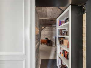 Hall featuring concrete flooring and wood walls